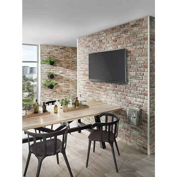 Panel de pared Ultra light Ladrillo - 120 x 50 cm, 2 ud. - Un comedor con una mesa de madera larga, sillas negras y una pared de ladrillos con un televisor.