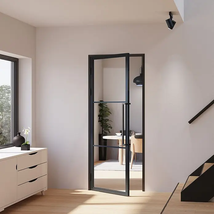 Inova Zimmertür Glasdrehtür ESG Glastür Komplettset 830 x 2115 Klarglas Griffstange - 830 x 2.115 mm, DIN Anschlag: Links, Schwarz - Schwarz gerahmte Glastür, teilweise geöffnet, die zwei moderne Räume verbindet.