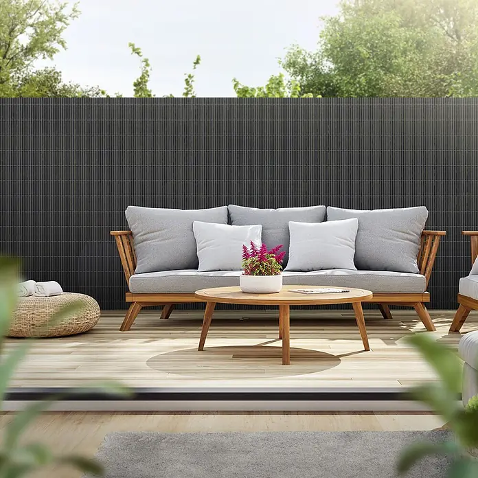 ECD Germany Sichtschutzelement Anthrazit Windschutz Zaunblende für Garten Balkon Terrasse - B x H: 500 x 140 cm, Kunststoff, Anthrazit - Dunkelgrauer Lamellen-Sichtschutz auf einer Terrasse hinter einem Holzsofa.