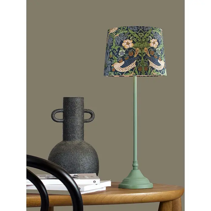 PR Home Tischleuchte blau - 40 W, E27 - Grüne Tischleuchte mit dunkelblauem Vogel- und Blumenmuster-Schirm neben einer strukturierten schwarzen Vase auf einem Holztisch.