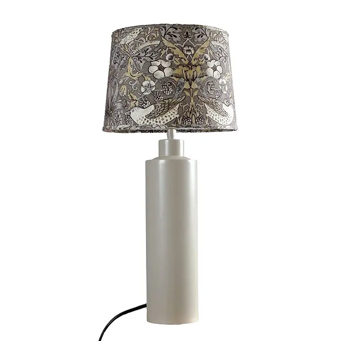 PR Home Tischleuchte Solo - 40 W, E27 - Tischlampe mit cremefarbenem zylindrischem Sockel und einem gemusterten Trommelschirm mit Vögeln und Blättern in Grau- und Gelbtönen.