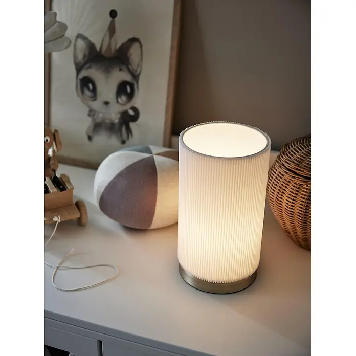PR Home Tischleuchte Dora - 25 W, E27 - Eine weiße plissierte Tischlampe mit Messingsockel, die ein warmes, sanftes Licht ausstrahlt.