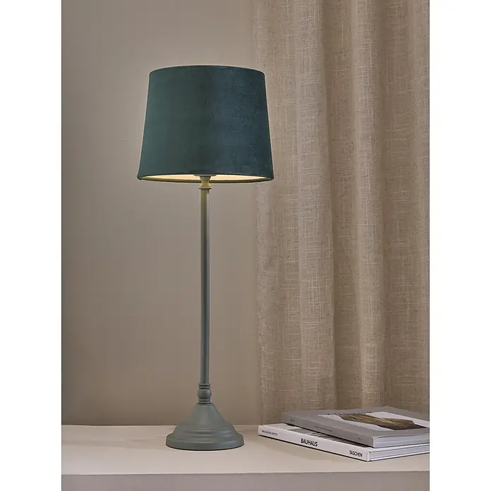PR Home Tischleuchte Tove - 40 W, E27 - Dunkelgrüne Samt-Tischlampe mit passendem Fuß, auf einer Fläche neben Büchern.
