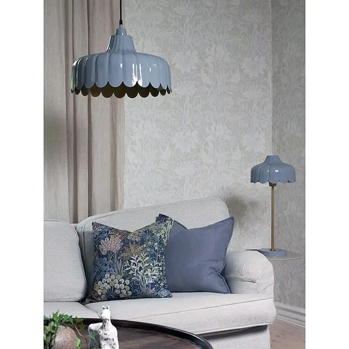 PR Home Tischleuchte Wells - 25 W, E27 - Blaue Pendelleuchte mit Wellenrand über einem Sofa und passende Tischlampe auf einem Beistelltisch, beide mit charakteristischem Wellendesign.