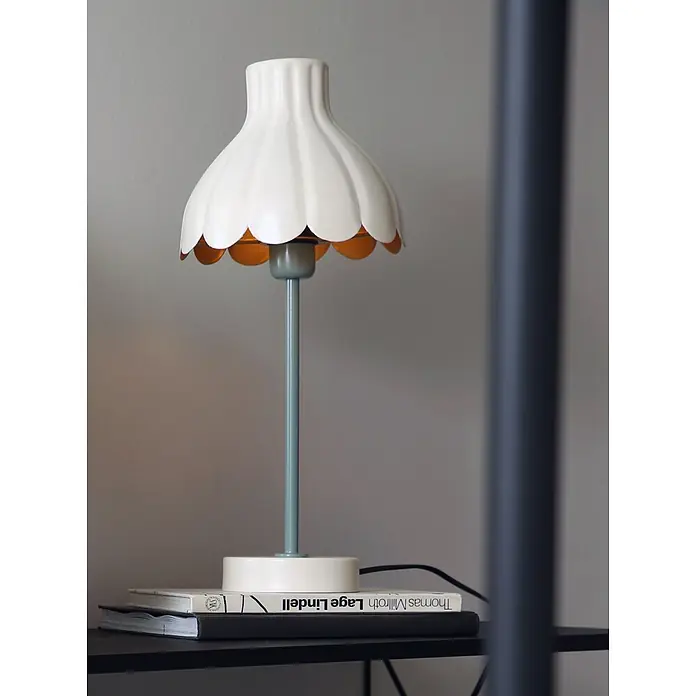 PR Home Tischleuchte Wera - 25 W, E27 - Tischlampe mit gewelltem cremefarbenem Schirm und mintgrünem Stiel und Sockel, auf Büchern stehend.