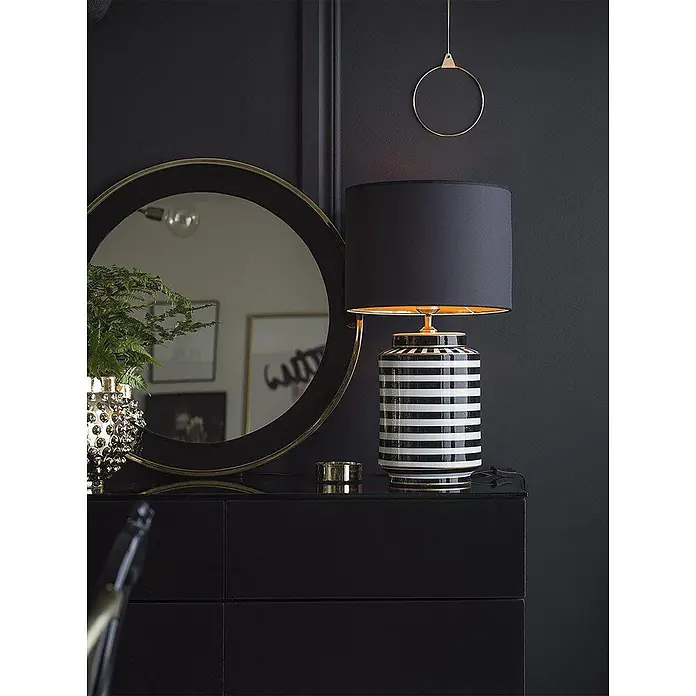 PR Home Tischleuchte 63cm - 40 W, E27 - Schwarz-weiß gestreifte Tischlampe mit schwarzem Schirm und Goldakzenten, auf dunklem Sideboard neben Spiegel.