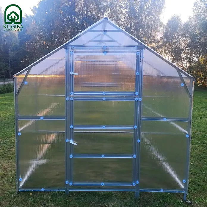 Klasika Greenhouses Gewächshaus Bernard Klasika - Außenmaß inkl. Dachüberstand (B x T): 235 x 500 cm, Material Seitenwand: Kunststoff, 6 mm, Silbergrau - Gewächshaus mit Metallrahmen und transparenten Polycarbonatplatten, auf Rasen im Freien.