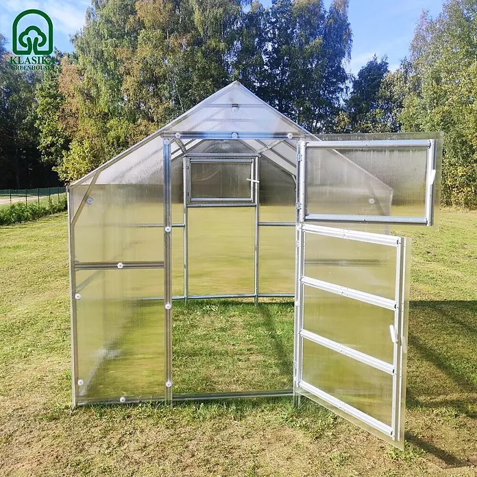Klasika Greenhouses Gewächshaus Bernard Klasika - Außenmaß inkl. Dachüberstand (B x T): 235 x 500 cm, Material Seitenwand: Kunststoff, 6 mm, Silbergrau - Transparentes Polycarbonat-Gewächshaus mit Metallrahmen, offener Tür und Dachfenster im Freien.