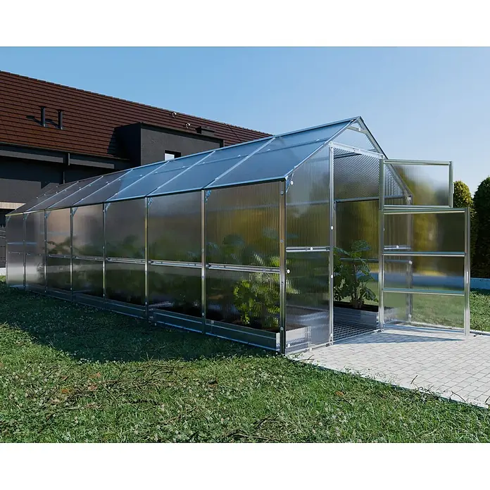 Klasika Greenhouses Gewächshaus Bernard Klasika - Außenmaß inkl. Dachüberstand (B x T): 235 x 700 cm, Material Seitenwand: Kunststoff, 4 mm, Silbergrau - Langes Gewächshaus mit transparenten Platten und Metallrahmen, im Garten mit Pflanzen darin.