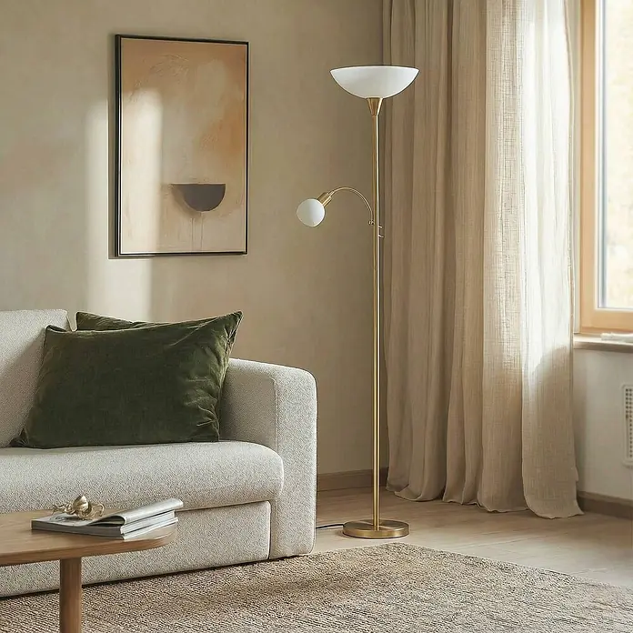 Lindby LED-Deckenfluter Elaina - Höhe: 182,5 cm, messing / gold - Messingfarbene Stehlampe mit Deckenfluter und verstellbarer Leselampe, beleuchtet ein gemütliches Wohnzimmer neben einem Sofa.