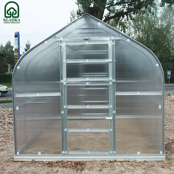 Klasika Greenhouses Gewächshaus Standart Klasika - Außenmaß inkl. Dachüberstand (B x T): 250 x 400 cm, Material Seitenwand: Kunststoff, 6 mm, Silbergrau - Großes gewölbtes Polycarbonat-Gewächshaus mit Metallrahmen und Scharniertür, auf Kiesgrund im Freien.