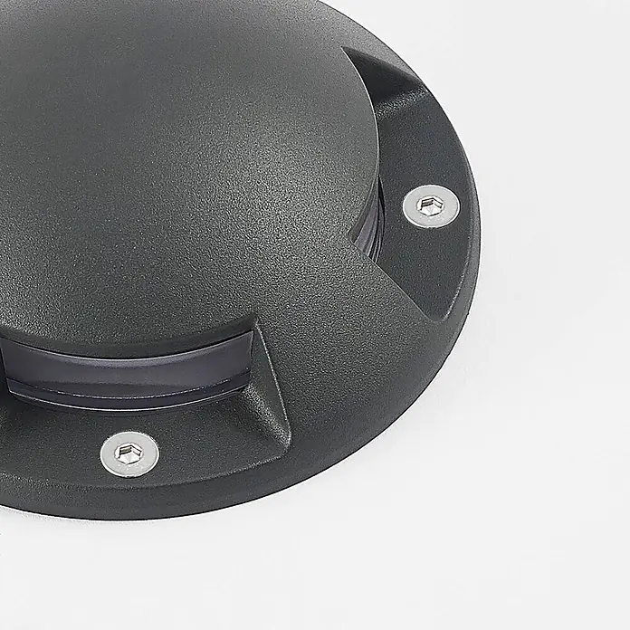 Lindby LED-Gartenstrahler Huban - 3.000 K - Dunkelgraue, körnige Bodeneinbauleuchte mit transparenter gekrümmter Linse und zwei sichtbaren Sechskantschrauben.