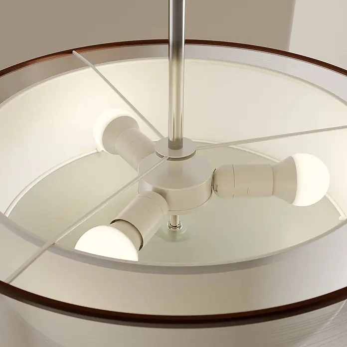 Lindby Deckenleuchte Pikka - braun / rost, E27 - Drei LED-Birnen in einer weißen Zentralbefestigung, aufgehängt an einer gebürsteten Metallstange, in einem weißen Stoff-Pendelleuchtenschirm mit dunklem Holzrand.