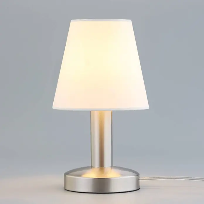 Lindby Tischleuchte Hanno - L x B x H: 14 x 14 x 24,5 cm, weiß / opal, E14 - Eine beleuchtete kleine Tischlampe mit weißem Stoffschirm und gebürstetem silberfarbenem Metallsockel.