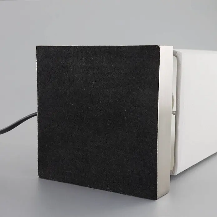 Lindby Tischleuchte Julina - L x B x H: 12 x 12 x 35 cm, alu / grau / zink, alu / grau / zink, E14 - Unterseite einer weißen, rechteckigen Lampe oder eines Lautsprechers mit schwarzem Filzboden und silbernem Metallrand. Ein schwarzes Kabel führt von der Seite.