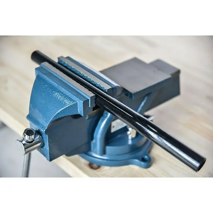 Tornillo de banco - 150 mm, Orientable 360°, Metal - Un tornillo de banco azul que sujeta un tubo negro de forma segura. La herramienta garantiza una sujeción firme para un trabajo preciso.
