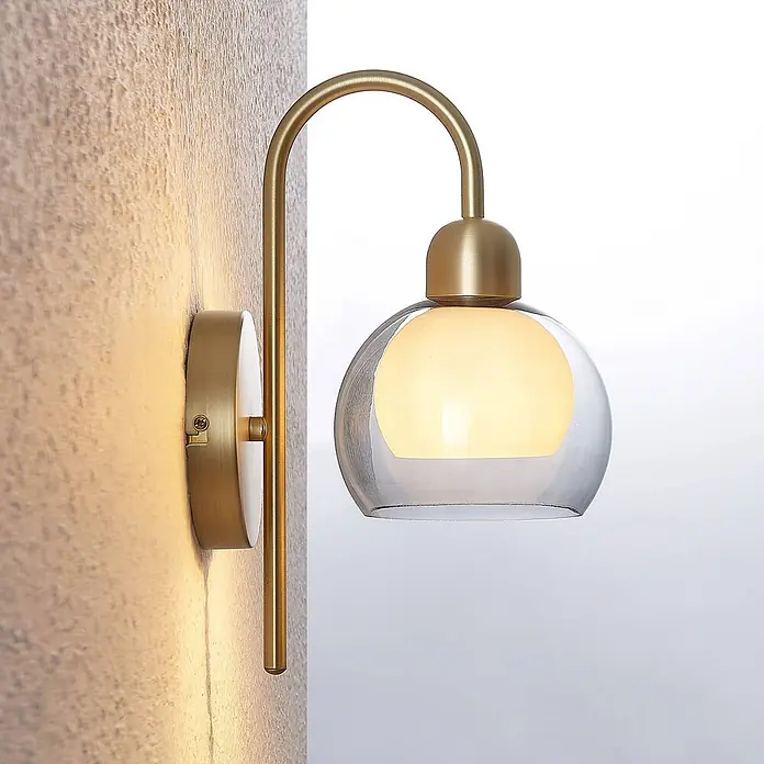 Lucande Wandleuchte Mylah - messing / gold, weiß / opal, E14 - Wandleuchte aus gebürstetem Messing mit klarer Glaskugel und opaker Innenlichtquelle, die warmes Licht abstrahlt.