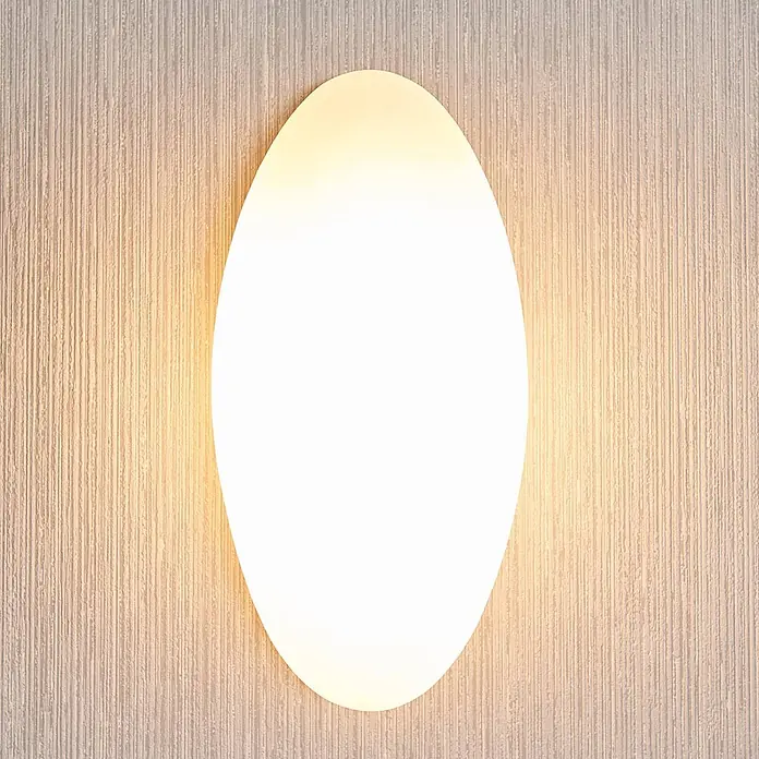 Lucande Wandleuchte Jemima - L x B x H: 8 x 12 x 24 cm, weiß / opal, E14 - Ovales Wandlicht mit weißem Diffusor, das einen warmen Schein auf eine strukturierte Wand wirft.