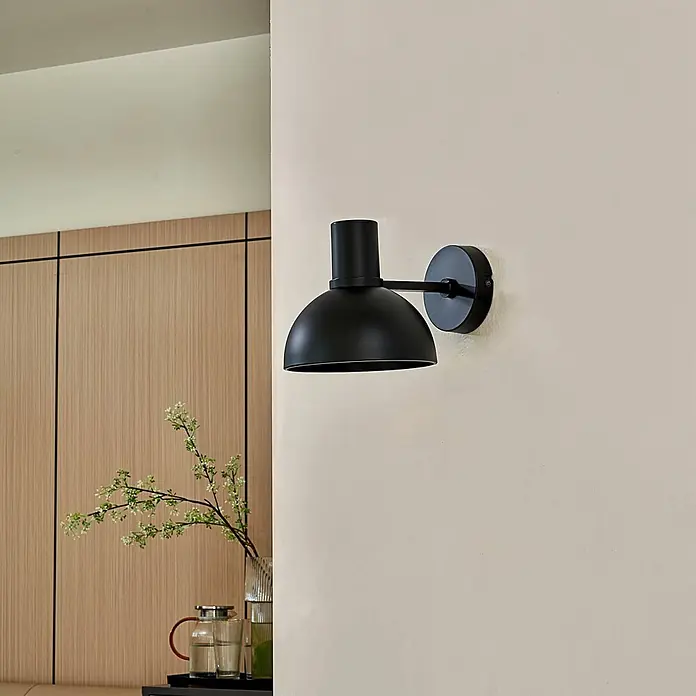 Lucande Wandleuchte Mostrid - L x B x H: 24 x 17 x 19,3 cm, schwarz, schwarz, E27 - Schwarze, kuppelförmige Wandleuchte an einer beigefarbenen Wand in einem modernen Interieur.