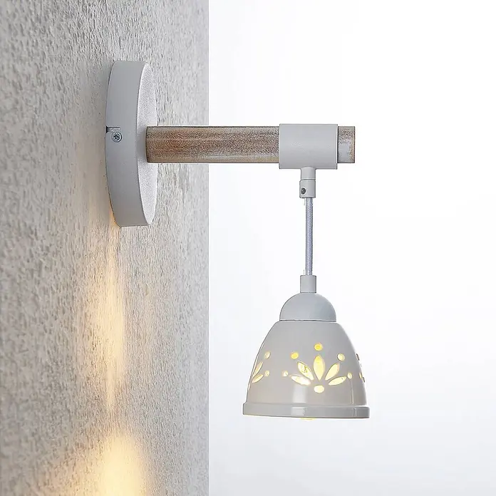 Lindby Wandleuchte Pimana - Holz hell, weiß / opal, E14 - Wandlampe mit weißem Keramik-Perforationsschirm und Holzarm, beleuchtet die Wand.