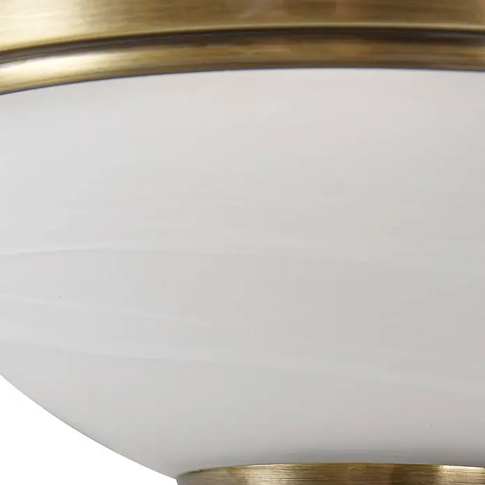 Lindby Wandleuchte Irimia - bronze / altmessing, E27 - Nahaufnahme einer Leuchte mit messingfarbenem Metallsockel und weißem, leicht marmoriertem Glasdiffusor.