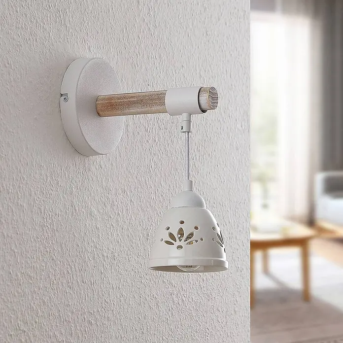 Lindby Wandleuchte Pimana - Holz hell, weiß / opal, E14 - Weiße Wandleuchte aus Keramik mit gemustertem Schirm und Holzarm, an einer strukturierten Wand befestigt.