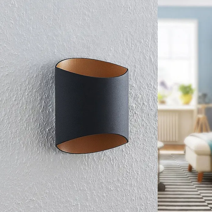 Arcchio Wandleuchte Vilja - schwarz, G9 - Moderne anthrazitfarbene Wandleuchte mit kupferfarbener Innenseite, an einer strukturierten Wand montiert.