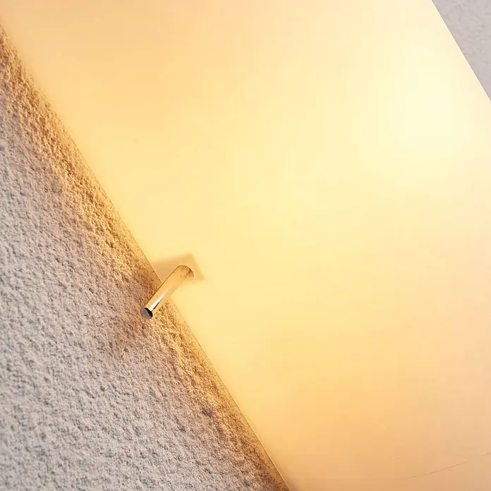 Lindby Wandleuchte Tuli - L x B x H: 7,4 x 15 x 28 cm, weiß / opal, E14 - Warm leuchtende Wandleuchte mit mattem Diffusor und einem kleinen Metallhalter vor einer strukturierten Wand.