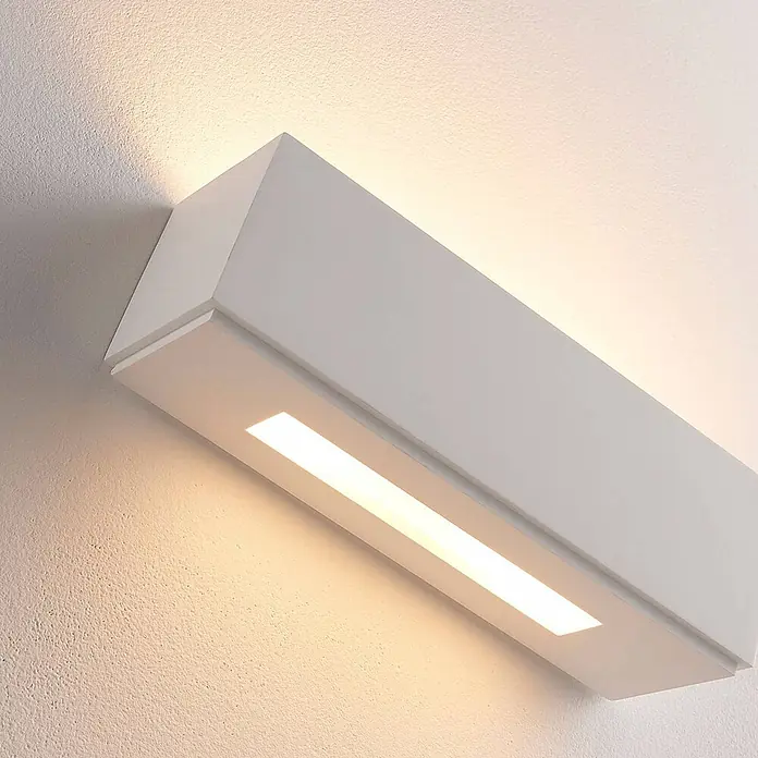 Lindby Wandleuchte Benno - L x B x H: 9 x 29 x 9 cm, weiß / opal, G9 - Eine moderne, weiße rechteckige LED-Wandleuchte an einer strukturierten Wand, die warmes Auf- und Ablicht spendet.