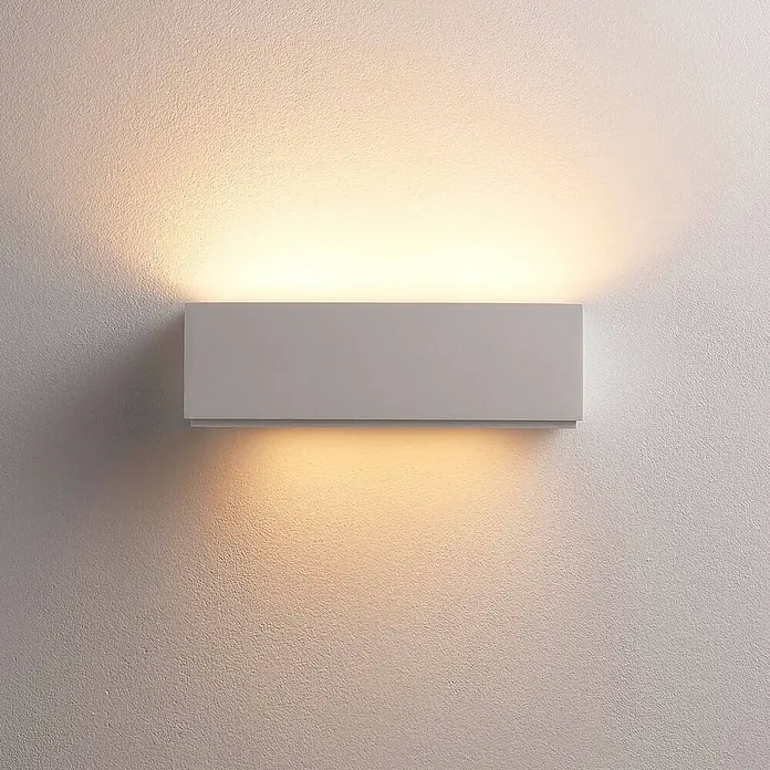 Lindby Wandleuchte Benno - L x B x H: 9 x 29 x 9 cm, weiß / opal, G9 - Graue rechteckige Wandleuchte, die warmes Licht nach oben und unten auf eine strukturierte Wand wirft.