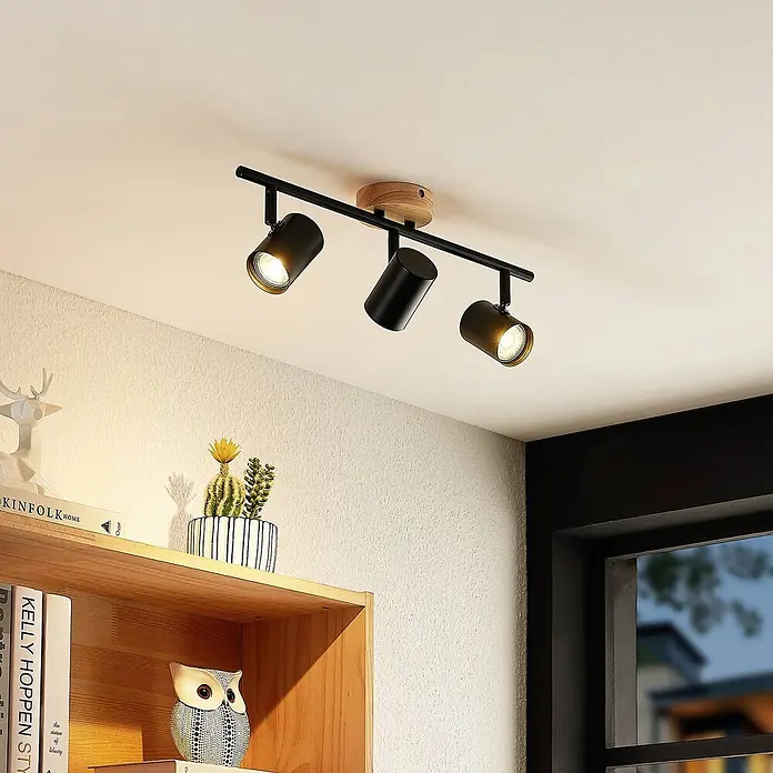 Lindby Deckenleuchte Xiomara - schwarz, GU10 - Schwarzer Deckenstrahler mit drei verstellbaren Leuchten und Holzsockel, an der Decke montiert.