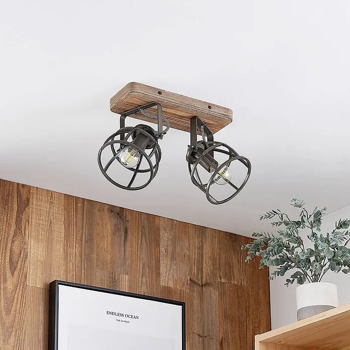 Lindby Deckenleuchte Rutger - Holz dunkel, schwarz, E14 - Industrieller Deckenstrahler mit zwei dunklen Metallkäfiglampen auf rustikalem Holzsockel.