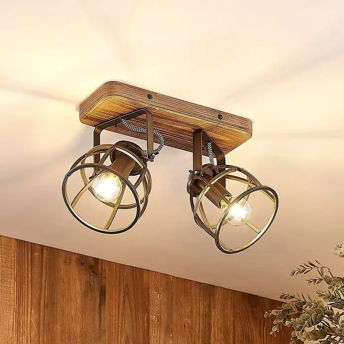Lindby Deckenleuchte Rutger - Holz dunkel, schwarz, E14 - Zweiflammiger Deckenstrahler im Industriestil aus dunklem Holz und Bronze, beleuchtet einen Raum von oben.