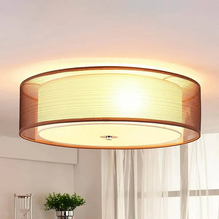 Lindby Deckenleuchte Tobia - L x B x H: 50 x 50 x 14,5 cm, braun / rost, E27 - Runde braune Stoff-Deckenleuchte mit weißem Diffusor, die einen Raum beleuchtet.