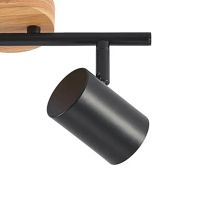 Lindby Deckenleuchte Xiomara - Holz hell, schwarz, GU10 - Schwarzer zylindrischer Strahler mit Naturholzbasis, an schwarzer Metallschiene montiert.
