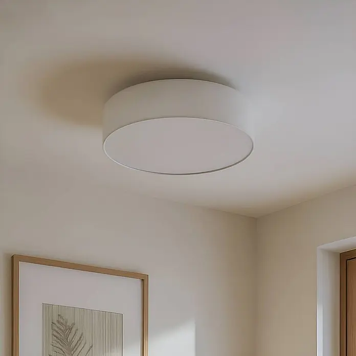Lindby Textil Deckenleuchte rund 50 cm, Deckenlampe Stoff cremeweiß -  - Eine weiße, runde Deckenleuchte aus Stoff beleuchtet einen modernen Raum, flach an der hellen Decke montiert.