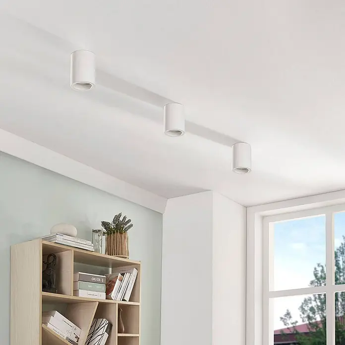 Lindby Deckenleuchte Annelies - weiß / opal, GU10 - Drei weiße, zylindrische Aufbauleuchten an der Decke eines modernen Raumes.