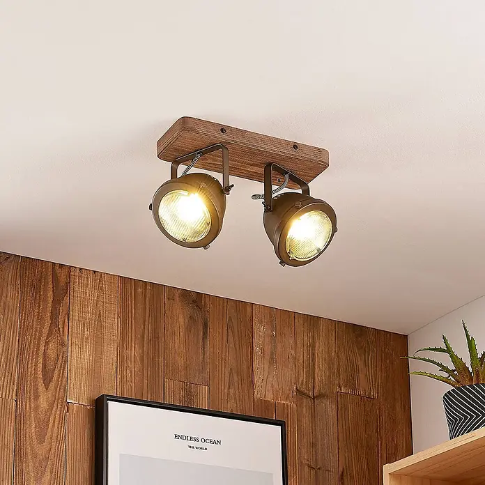 Lindby Deckenstrahler Farovi - Holz dunkel, schwarz, GU10 - Zwei industrielle Deckenstrahler mit dunklen Metallköpfen auf rustikaler Holzbasis, die einen Raum beleuchten.