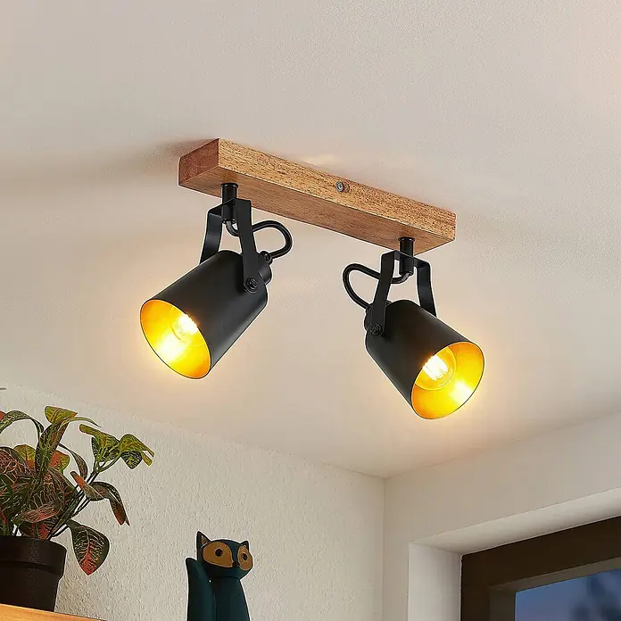 Lindby Deckenstrahler Kimban - L x B x H: 35,5 x 8,3 x 15,8 cm, Holz dunkel, schwarz, E14 - Zwei schwarze Deckenstrahler mit goldenen Innenseiten auf einem Holzriegel, an der Decke montiert, warmes Licht abgebend.
