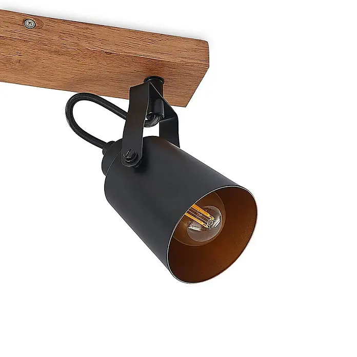 Lindby Deckenstrahler Kimban - L x B x H: 35,5 x 8,3 x 15,8 cm, Holz dunkel, schwarz, E14 - Schwarzer Deckenstrahler aus Metall mit bronzefarbenem Interieur und sichtbarer Glühbirne, montiert auf einem Holzbalken.