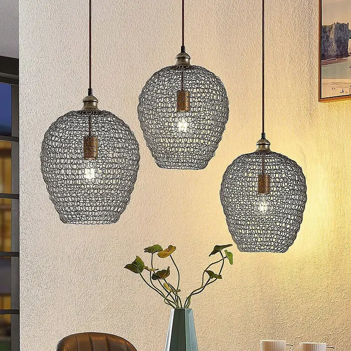 Lindby Pendelleuchte Benja - schwarz, messing, E27 - Drei runde Pendelleuchten aus Metallgeflecht mit Messingdetails beleuchten einen Raum.