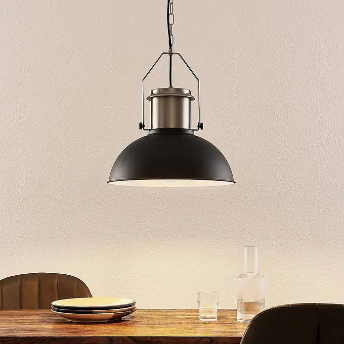 Lindby Pendelleuchte Freitjof - schwarz, Schwarz matt, nickel matt, E27 - Schwarze Industrie-Pendelleuchte mit gebürstetem Metall, die einen Esstisch beleuchtet.