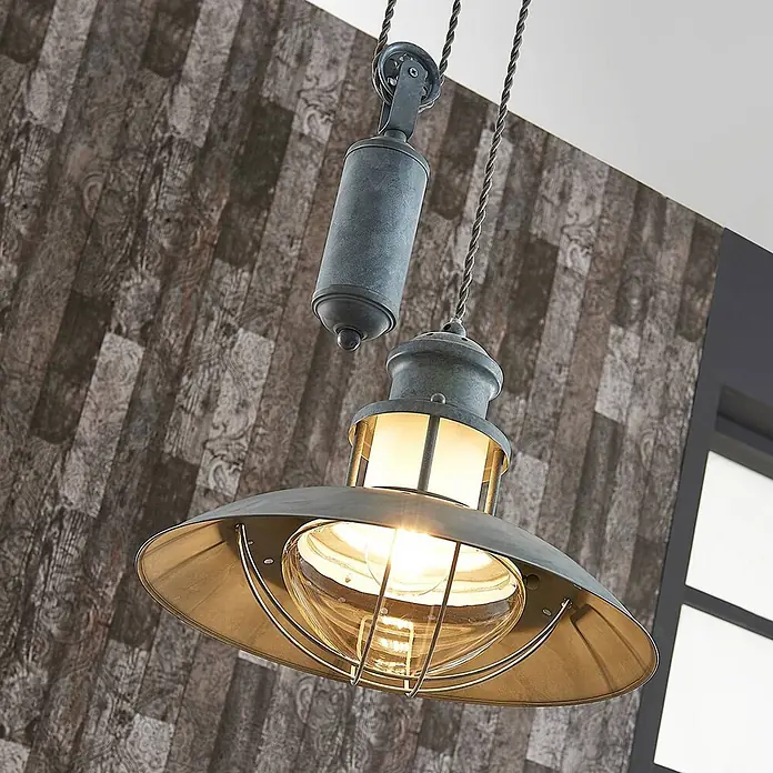 Lindby Pendelleuchte Louisanne - L x B x H: 35 x 35 x 25,7 cm, alu / grau / zink, grau-Grün, klar, E27 - Industrielle Hängelampe aus grau-blauem Metall mit Flaschenzug, breitem Schirm und Glasglocke, vor einer gemusterten Wand.