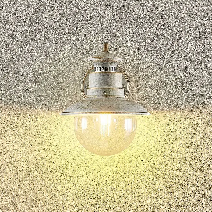 Lindby Außenwandleuchte Gwendolyn - weiß / opal, weiß / opal, IP44 - Antike Wandleuchte in Weiß-Gold mit Glaskugel, spendet warmes Licht an einer strukturierten Wand.