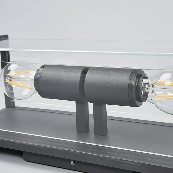 Lucande Außenwandleuchte Annalea - schwarz, klar / transparent, IP54 - Moderne dunkelgraue Tischleuchte mit zwei sichtbaren Edison-LED-Birnen in Klarglas, auf passendem Sockel.