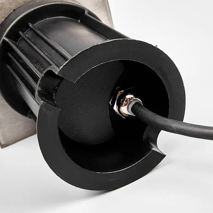 Lindby LED-Gartenstrahler Insa -  - Schwarzes Kunststoffgehäuse einer Leuchte mit elektrischem Kabel, gesichert durch eine metallische Kabelverschraubung.