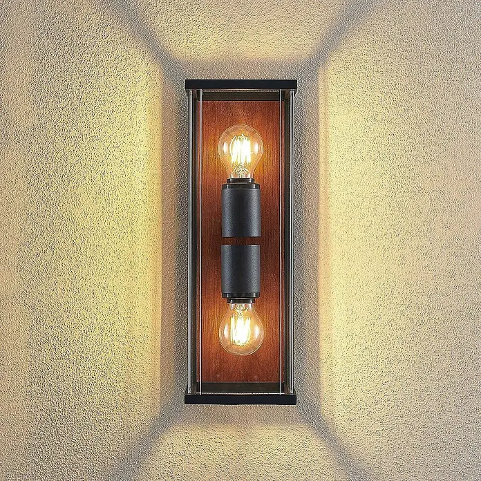Lucande Außenwandleuchte Elwin - schwarz, schwarz, IP54 - Schwarze Wandleuchte mit Holzrahmen und zwei Vintage-Glühbirnen, wirft warmes Licht auf eine strukturierte Wand.