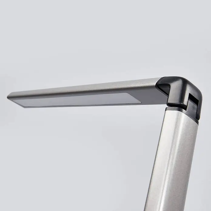 Lindby Tischleuchte Kuno - L x B x H: 37,6 x 15,8 x 46 cm, alu / grau / zink, alu / grau / zink - Nahaufnahme einer modernen silbernen Metall-LED-Schreibtischlampe mit Kopf und Arm sowie einem schwarzen Gelenk.