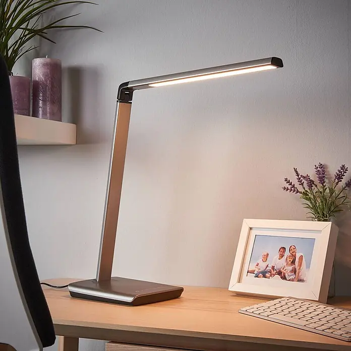 Lindby Tischleuchte Kuno - L x B x H: 37,6 x 15,8 x 46 cm, alu / grau / zink, alu / grau / zink - Moderne LED-Schreibtischlampe in Silber-Bronze-Optik auf einem Holzschreibtisch.