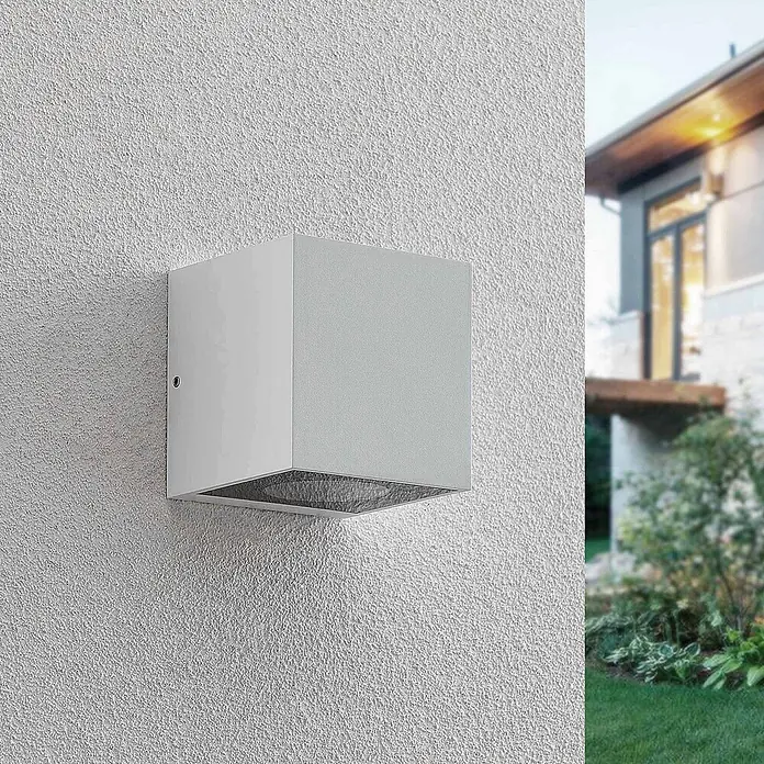 Arcchio Außenwandleuchte Tassnim - weiß / opal, weiß / opal, IP65 - Hellgraue, würfelförmige Außenwandleuchte an einer strukturierten Hauswand montiert.